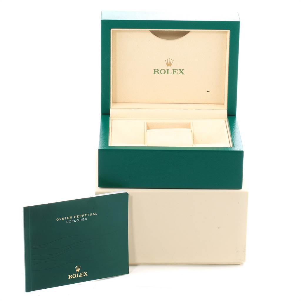 This image shows an open Rolex Explorer 214270 Men's Stainless Steel Black Dial 214270 Men's Stainless Steel Black Dial watch box and its official booklet placed next to it.