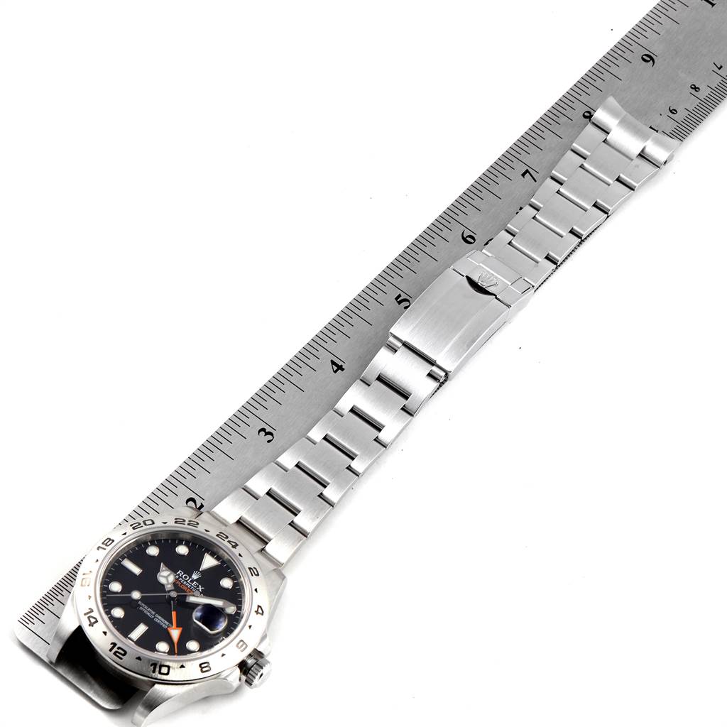 The Rolex Explorer 216570 Men's Stainless Steel Black Dial 216570 Men's Stainless Steel Black Dial watch is shown flat from a top view, displaying the face, bracelet, and clasp, with a ruler for scale.