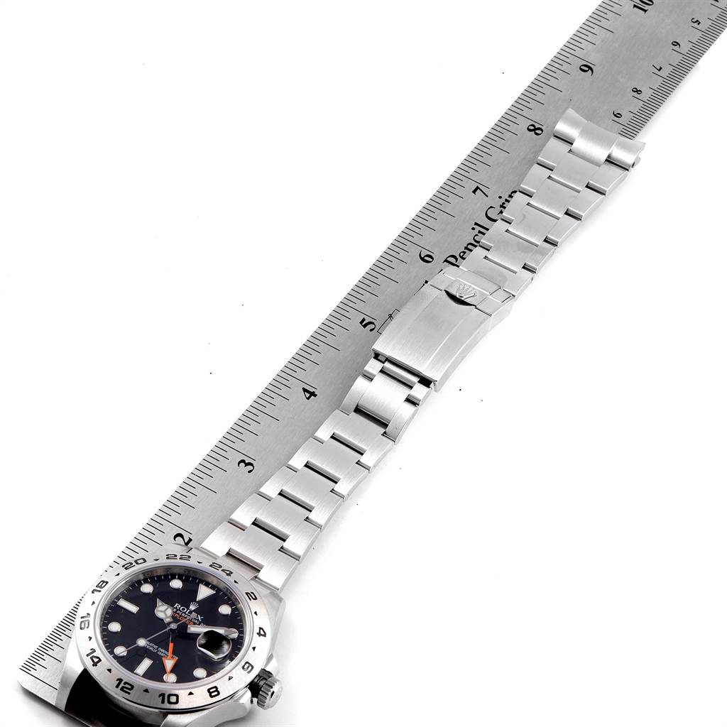 The Rolex Explorer 216570 Men's Stainless Steel Black Dial 216570 Men's Stainless Steel Black Dial watch is shown at an angle displaying the face, bracelet, and clasp, next to a ruler for measurement.