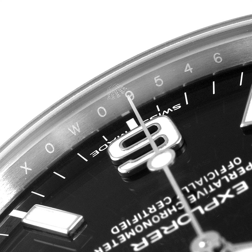 The image shows a close-up of the dial and bezel of a Rolex Explorer 214270 Men's Stainless Steel Black Dial 214270 Men's Stainless Steel Black Dial watch, highlighting the 9 o'clock marker and text.