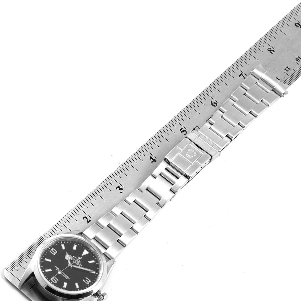 The image shows the Rolex Explorer 14270 Men's Stainless Steel Black Dial 14270 Men's Stainless Steel Black Dial watch face and bracelet laid flat next to a ruler.
