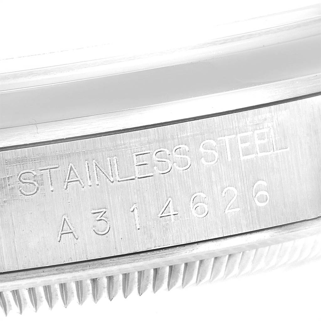 This close-up shows the side of the Rolex Explorer 14270 Men's Stainless Steel Black Dial 14270 Men's Stainless Steel Black Dial watch case, highlighting the engraved "STAINLESS STEEL" and serial number.