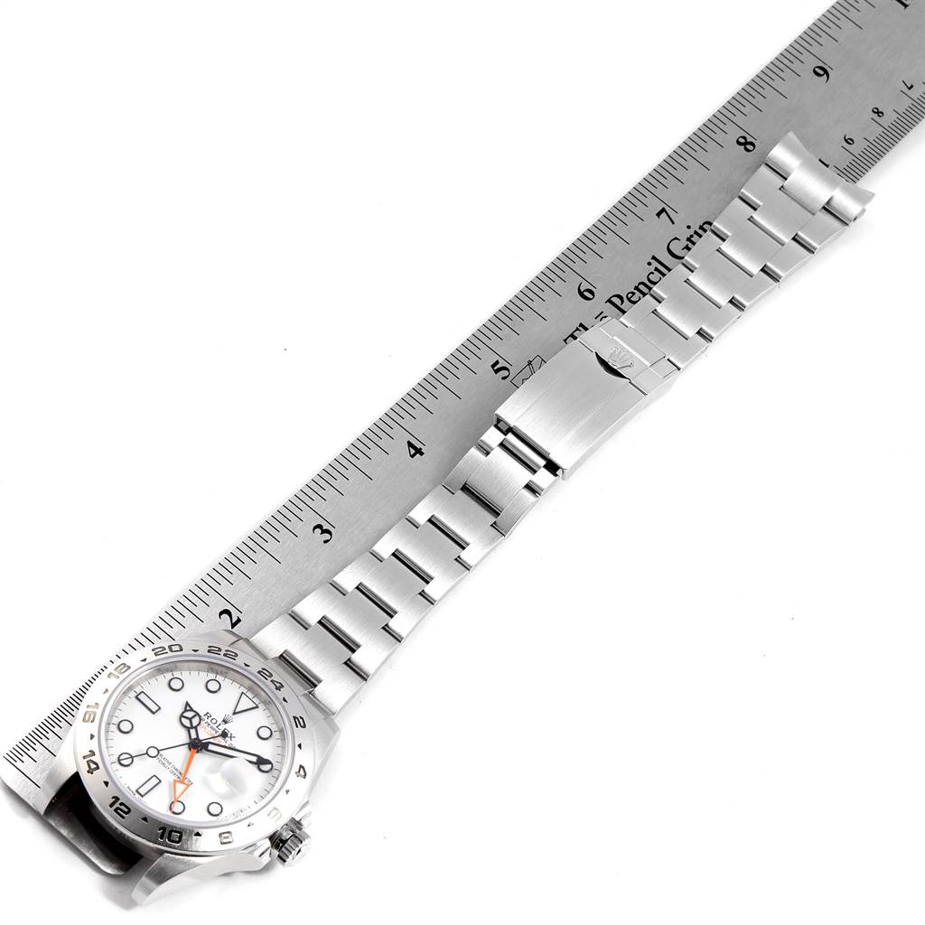 The image shows a Rolex Explorer 216570 Men's Stainless Steel White Dial 216570 Men's Stainless Steel White Dial watch horizontally aligned with a ruler, displaying its face, bezel, and metal bracelet.
