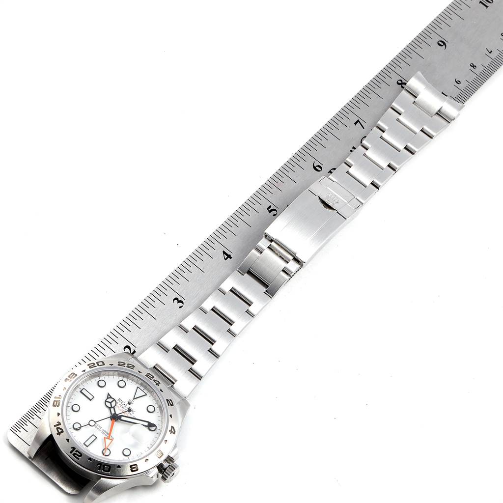 The image shows a top-down view of a Rolex Explorer 216570 Men's Stainless Steel White Dial 216570 Men's Stainless Steel White Dial watch, its face, and the metal bracelet against a ruler for scale.
