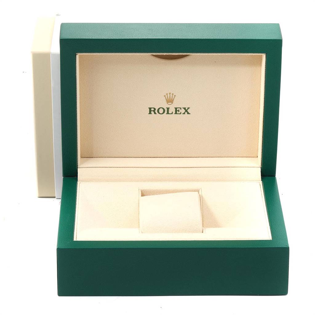 The image shows an open watch box for the Explorer model by Rolex, featuring a green exterior and beige interior.
