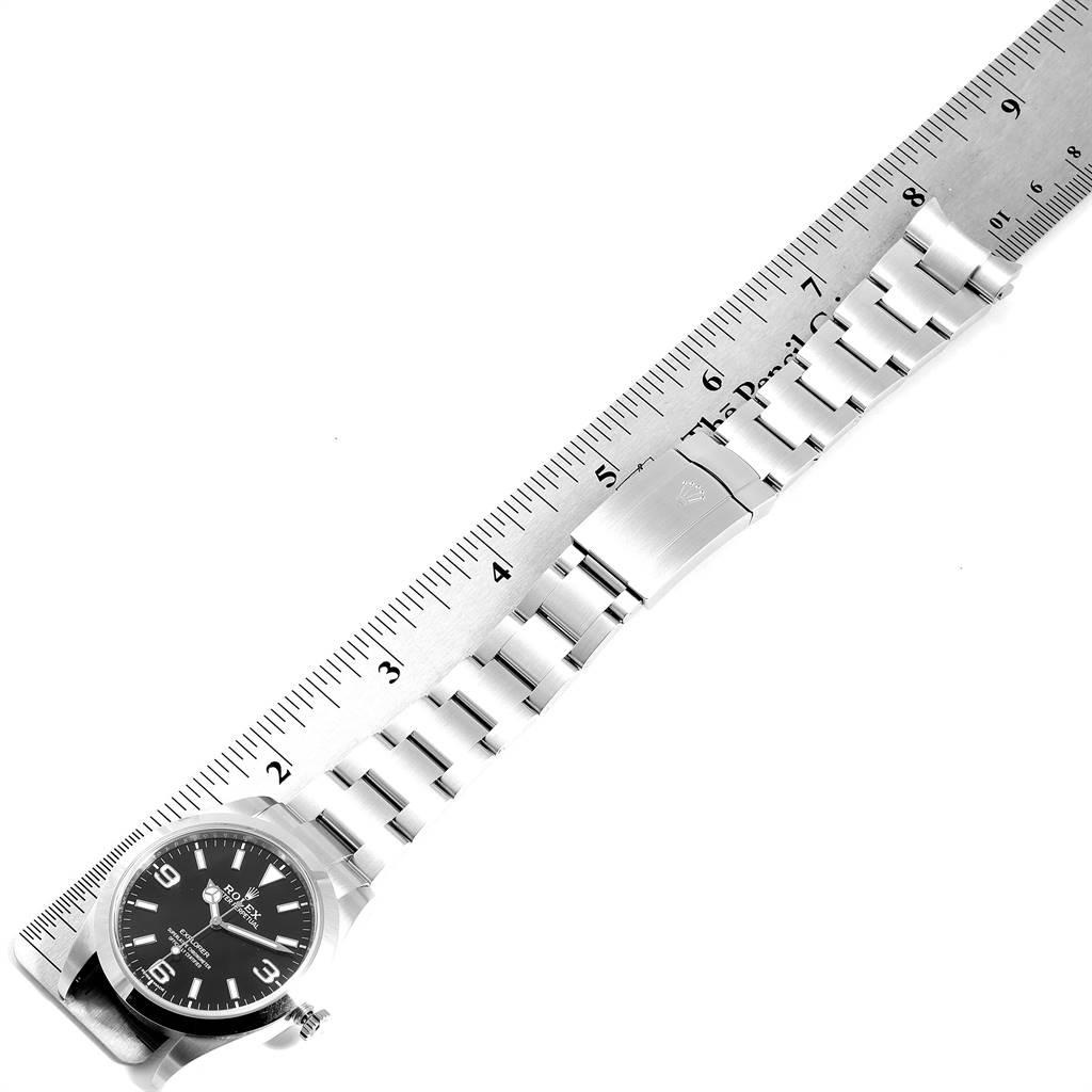 This image shows a top-down view of a Rolex Explorer 214270 Men's Stainless Steel Black Dial 214270 Men's Stainless Steel Black Dial watch, including the face, bracelet, and clasp, measured against a ruler.