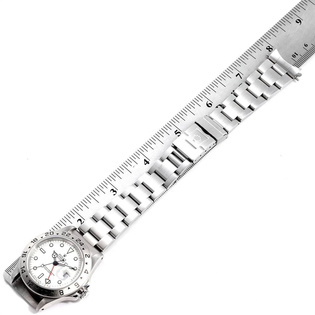 The image shows a Rolex Explorer 16570 Men's Stainless Steel White Dial 16570 Men's Stainless Steel White Dial watch placed alongside a ruler, highlighting its band and clasp.