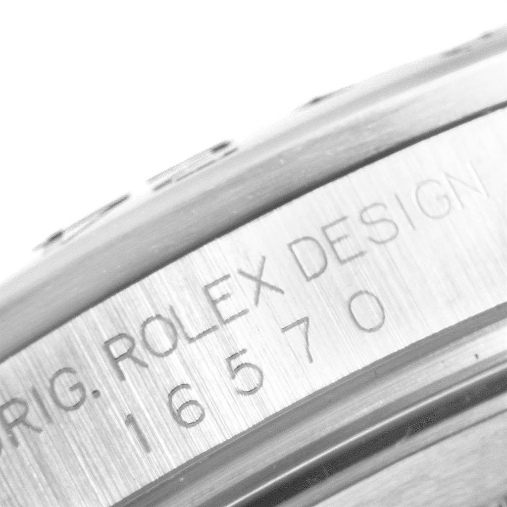 The image shows a close-up of the engraved side of a Rolex Explorer 16570 Men's Stainless Steel White Dial 16570 Men's Stainless Steel White Dial watch case, displaying the serial and model numbers.