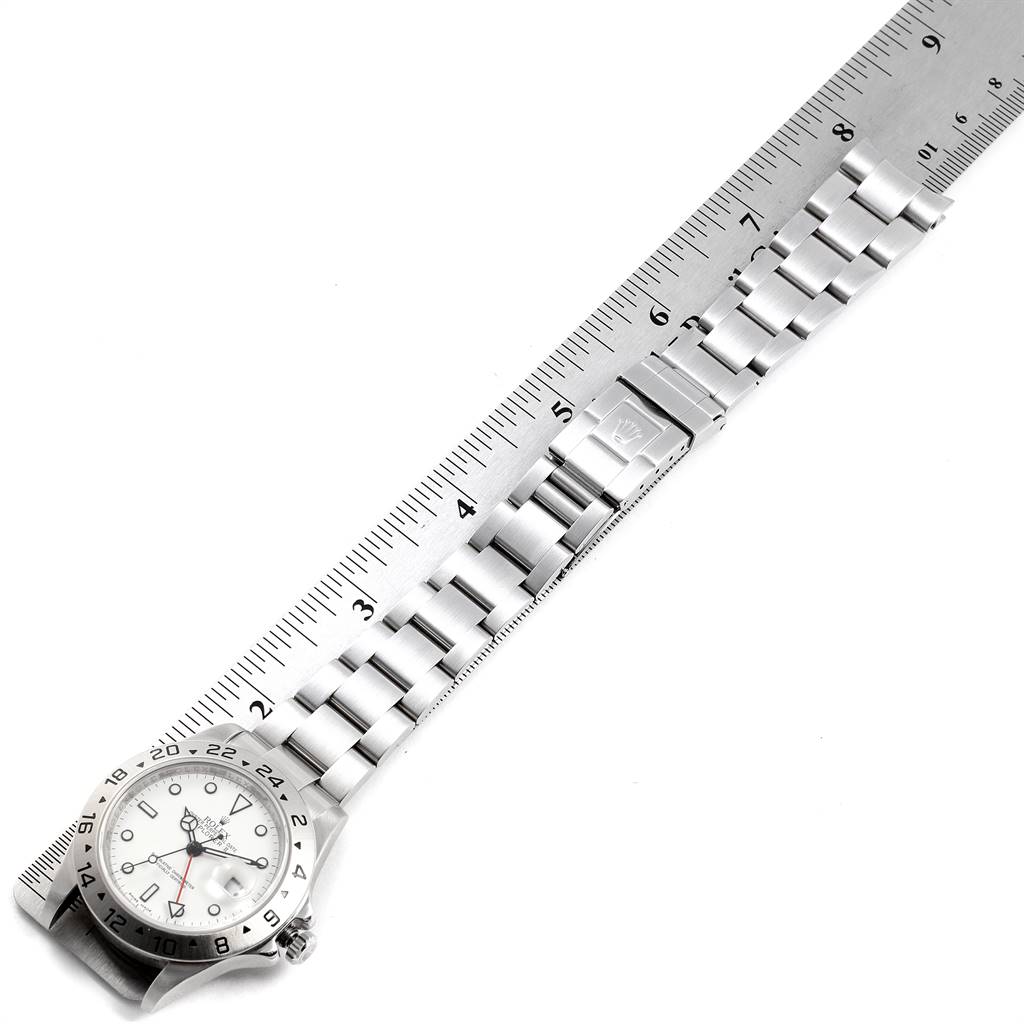 The image shows a top-down view of the Rolex Explorer 16570 Men's Stainless Steel White Dial 16570 Men's Stainless Steel White Dial watch, including its face and metal bracelet, alongside a ruler.