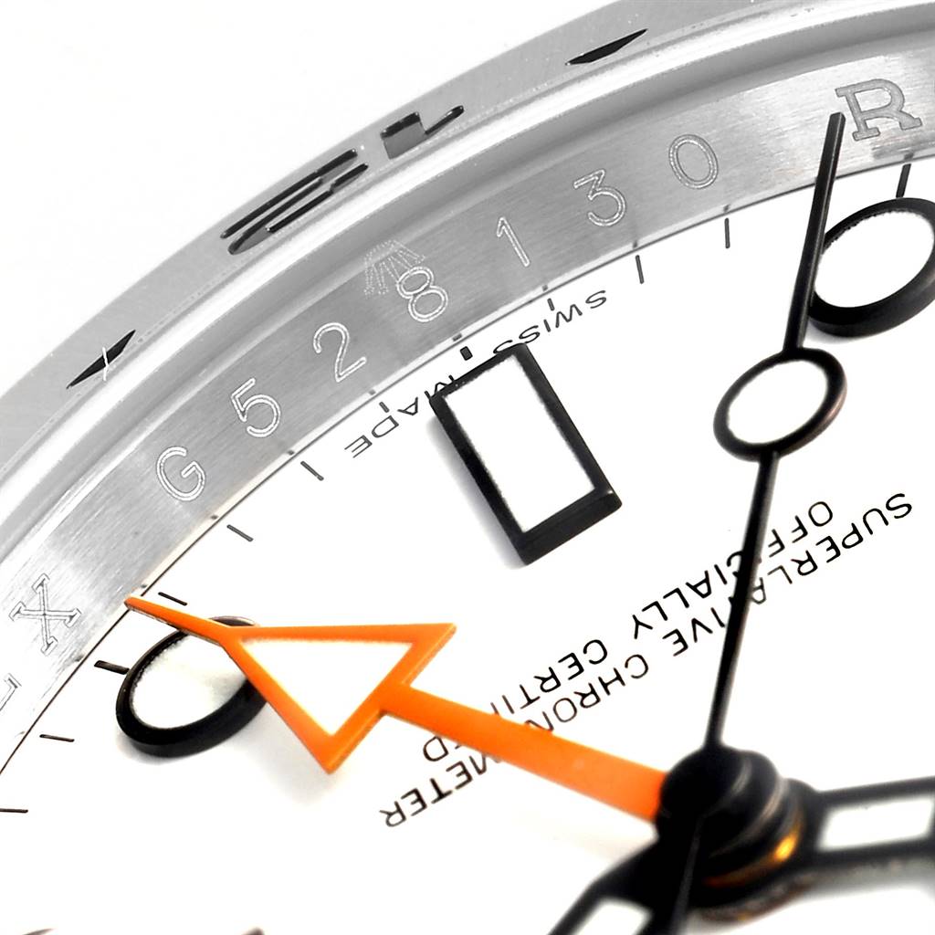 This close-up image of the Rolex Explorer 216570 Men's Stainless Steel White Dial 216570 Men's Stainless Steel White Dial model shows part of the dial, hands, indices, and rehaut with engraved serial numbers.