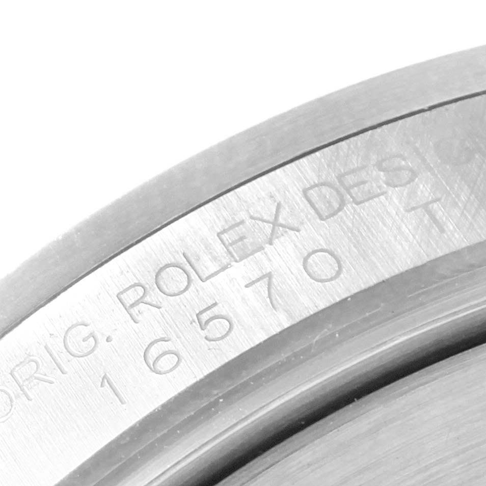 This close-up image shows the engraved serial number on the edge of a Rolex Explorer 16570 Men's Stainless Steel White Dial 16570 Men's Stainless Steel White Dial watch case.