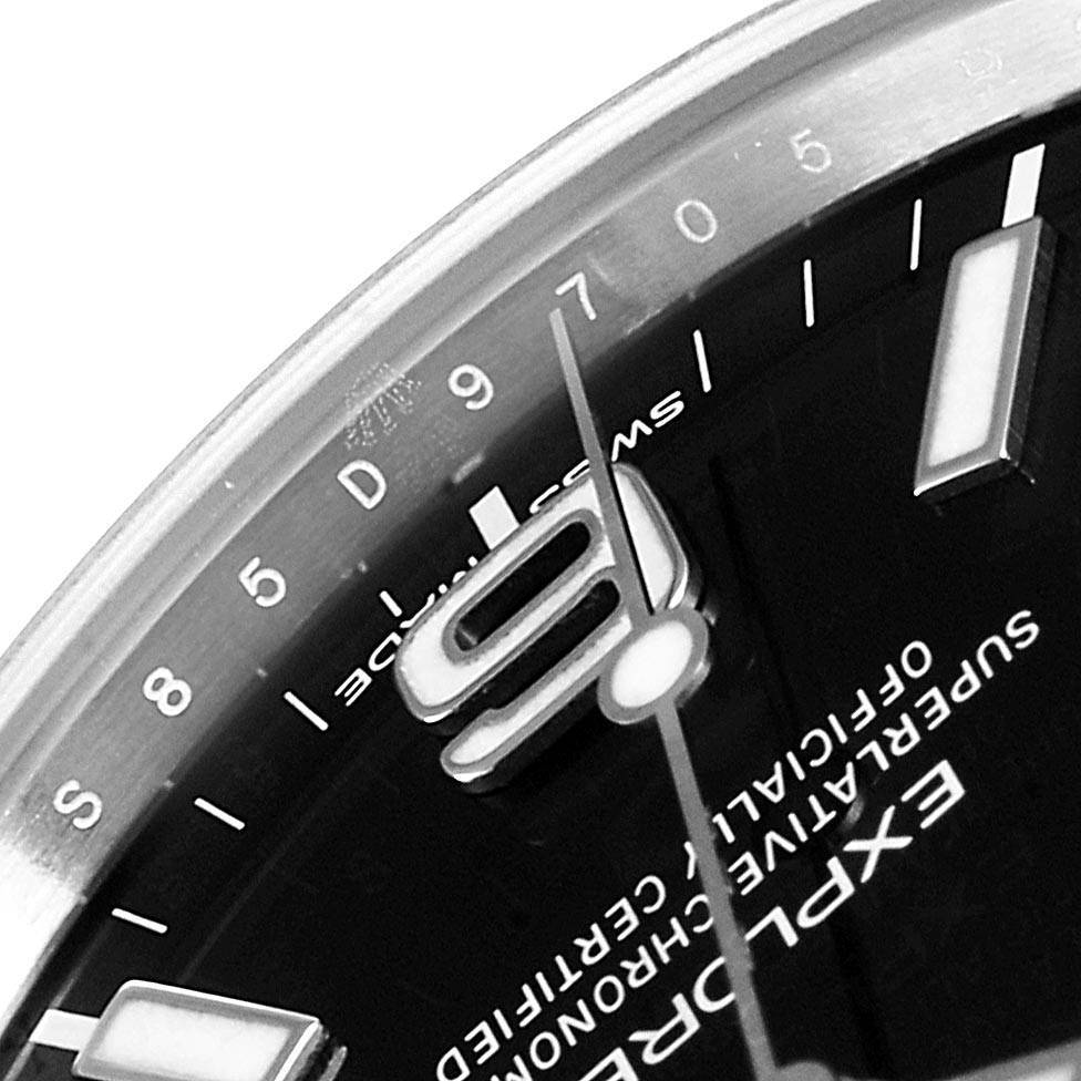 The image shows a close-up of the dial of a Rolex Explorer 214270 Men's Stainless Steel Black Dial 214270 Men's Stainless Steel Black Dial watch, highlighting the "9" numeral, minute markers, and part of the second hand.