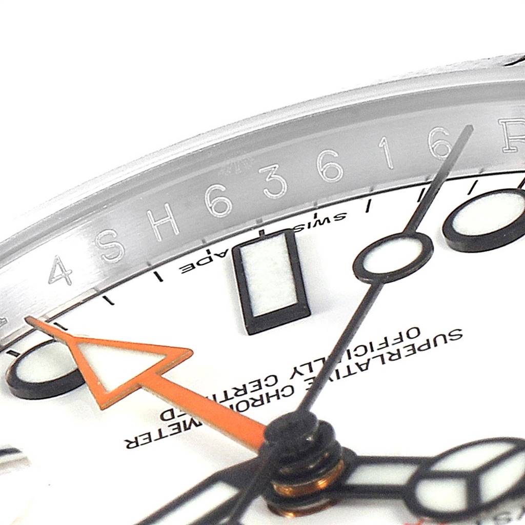 This close-up shot of the Rolex Explorer 216570 Men's Stainless Steel White Dial 216570 Men's Stainless Steel White Dial watch showcases the bezel, part of the dial, and hands.