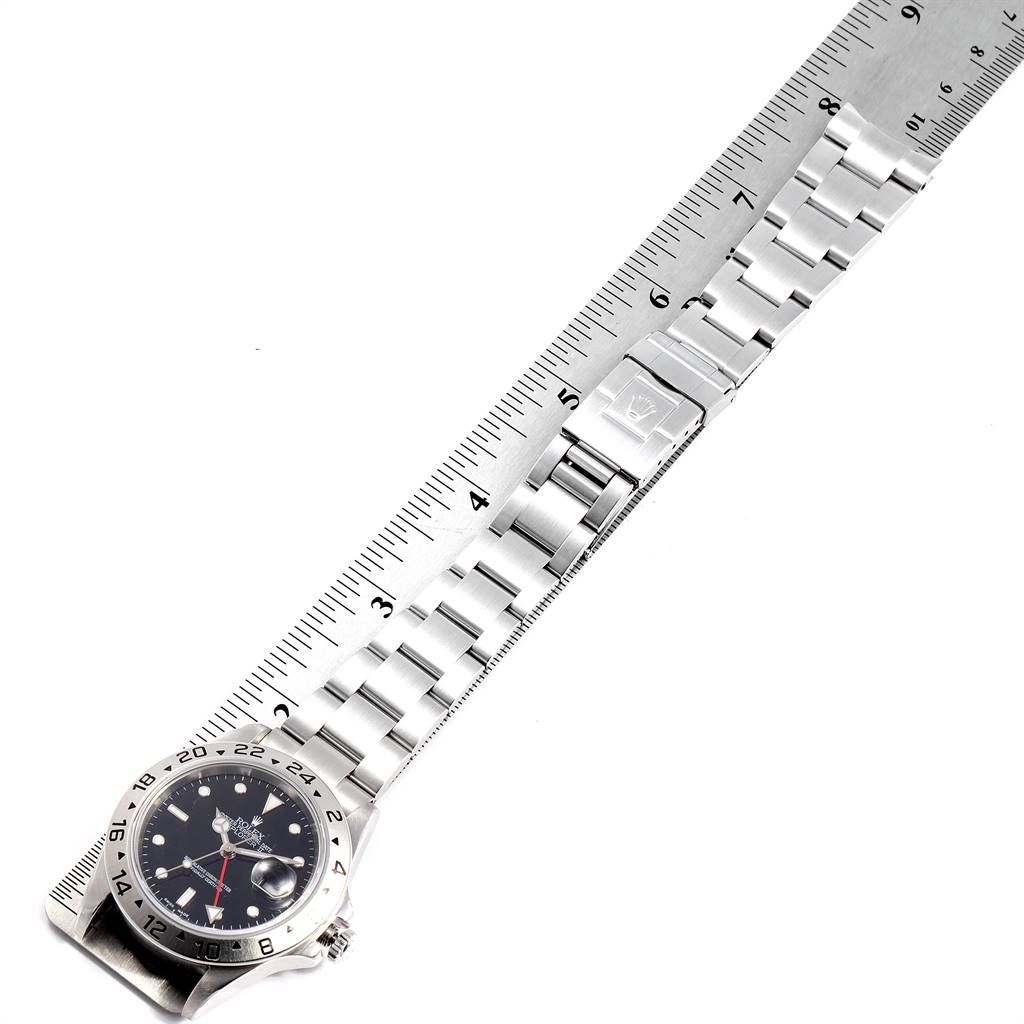 The image shows a Rolex Explorer 16570 Men's Stainless Steel Black Dial 16570 Men's Stainless Steel Black Dial watch lying flat with its bracelet extended next to a ruler.