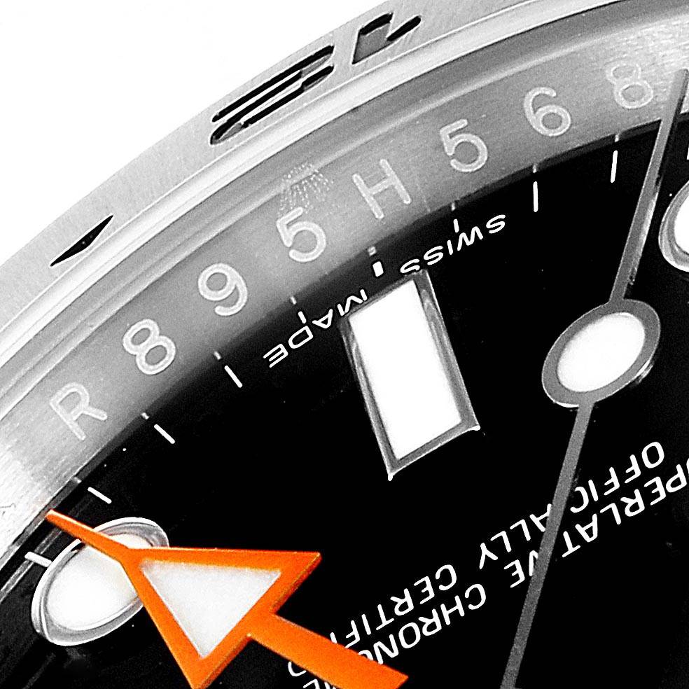 This image shows a close-up of the dial and bezel of a Rolex Explorer 216570 Men's Stainless Steel Black Dial 216570 Men's Stainless Steel Black Dial watch, highlighting the hour markers and an orange hand.