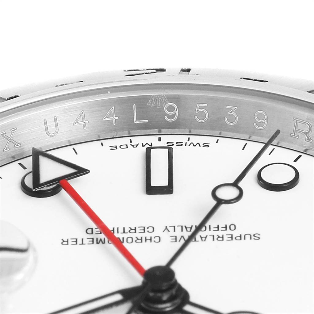 This close-up view of the Rolex Explorer 16570 Men's Stainless Steel White Dial 16570 Men's Stainless Steel White Dial watch shows part of the dial and minutes hand, along with the engraved serial number on the bezel.