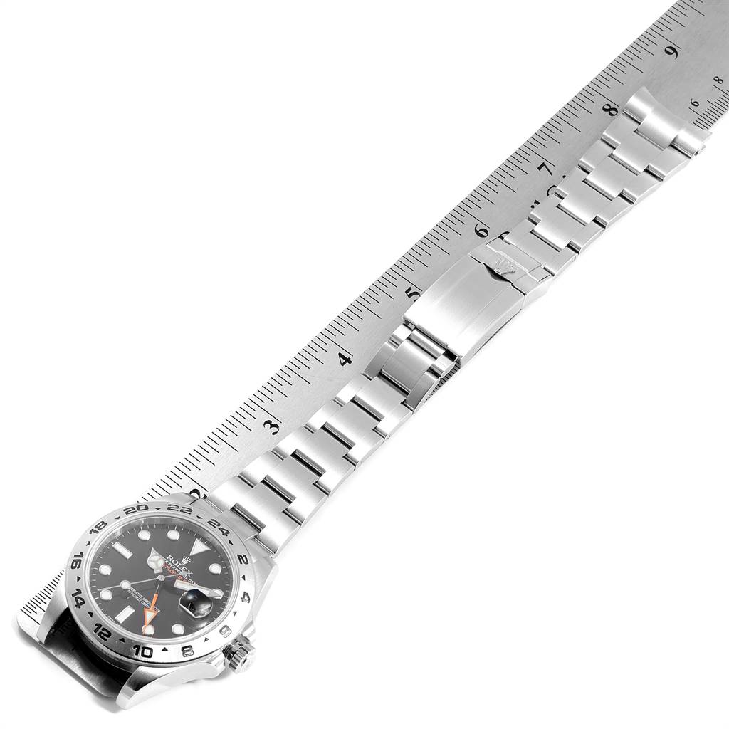 The image shows a top view of the Rolex Explorer 216570 Men's Stainless Steel Black Dial 216570 Men's Stainless Steel Black Dial watch, highlighting the bracelet, clasp, and face beside a ruler.