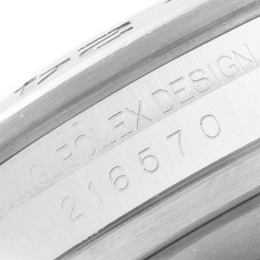 This image shows a close-up of the side of a Rolex Explorer 216570 Men's Stainless Steel Black Dial 216570 Men's Stainless Steel Black Dial model, specifically highlighting the engraved serial number and "ROLEX DESIGN" text.