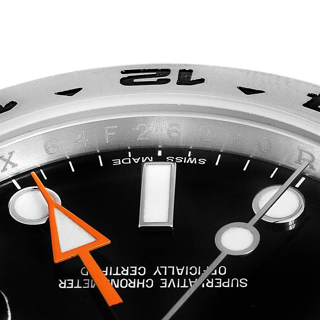 The close-up image of the Rolex Explorer 216570 Men's Stainless Steel Black Dial 216570 Men's Stainless Steel Black Dial watch shows the dial, hour markers, and the orange GMT hand.