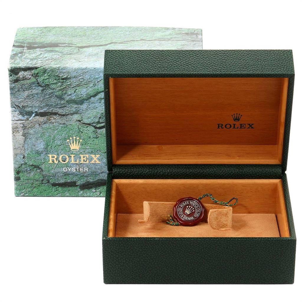 The image shows an open green Rolex watch box for the Explorer model, displaying the interior and a tag.