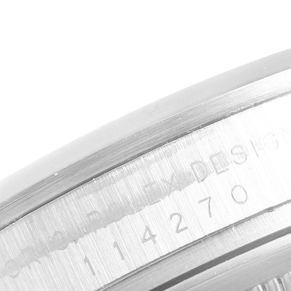 The image shows a close-up of the side engraving on the bezel of a Rolex Explorer 114270 Men's Stainless Steel Black Dial 114270 Men's Stainless Steel Black Dial watch.