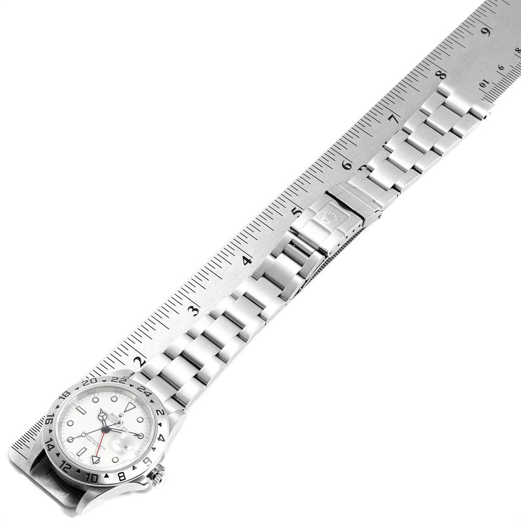 The image shows a top view of a Rolex Explorer 16570 Men's Stainless Steel White Dial 16570 Men's Stainless Steel White Dial watch, with its stainless steel bracelet laid next to a ruler for measurement.