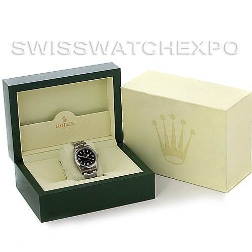 The image shows a Rolex Explorer 114270 Men's Stainless Steel Black Dial 114270 Men's Stainless Steel Black Dial watch in an open green box, next to its closed beige outer box with the Rolex logo.