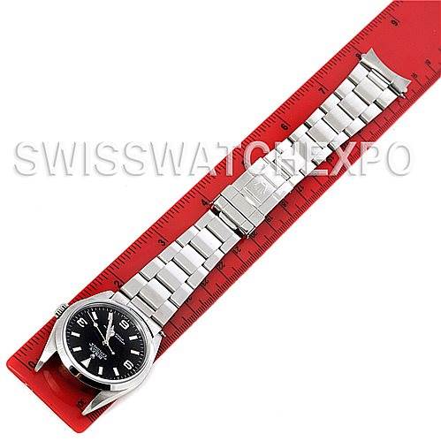 The image shows a Rolex Explorer 14270 Men's Stainless Steel Black Dial 14270 Men's Stainless Steel Black Dial watch laid flat on a red ruler, displaying the full bracelet and dial.