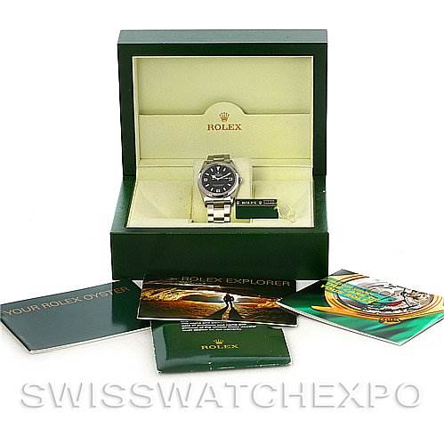 The image shows a Rolex Explorer 114270BKAO Men's Stainless Steel Black Dial 114270BKAO Men's Stainless Steel Black Dial watch in its open box with accompanying booklets and accessories.