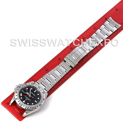 The image shows a top-down view of a Rolex Explorer 16570 Men's Stainless Steel Black Dial 16570 Men's Stainless Steel Black Dial watch laid on a red ruler, displaying the watch face and stainless steel bracelet.