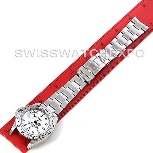 The Rolex Explorer 16570 Men's Stainless Steel White Dial 16570 Men's Stainless Steel White Dial watch is shown laid flat with its entire face and metal bracelet visible, aligned next to a red ruler for scale.