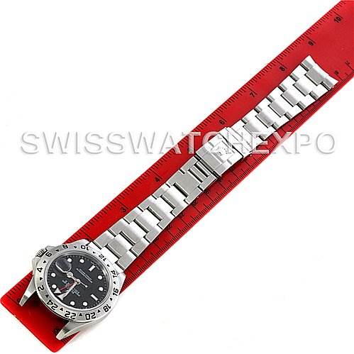 The image displays a Rolex Explorer 16570 Men's Stainless Steel Black Dial 16570 Men's Stainless Steel Black Dial watch laid flat with its bracelet extended and aligned next to a red ruler.