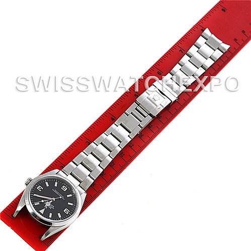 The image shows a Rolex Explorer 114270 Men's Stainless Steel Black Dial 114270 Men's Stainless Steel Black Dial watch laid flat against a red ruler, displaying the full watch face and bracelet.