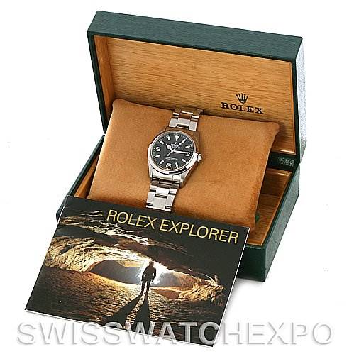 The image shows a Rolex Explorer 114270 Men's Stainless Steel Black Dial 114270 Men's Stainless Steel Black Dial model watch from a front angle, including its box and instruction booklet.