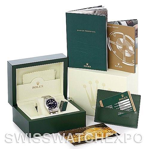 This image shows a Rolex Explorer 114270 Men's Stainless Steel Black Dial 114270 Men's Stainless Steel Black Dial watch in its box along with booklets, a warranty card, and other packaging accessories.