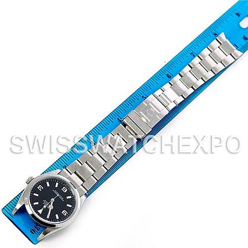 The image shows a full view of the Rolex Explorer 114270 Men's Stainless Steel Black Dial 114270 Men's Stainless Steel Black Dial watch, placed next to a blue ruler for size reference.