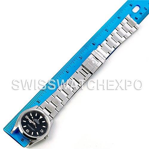 The image shows a Rolex Explorer 114270 Men's Stainless Steel Black Dial 114270 Men's Stainless Steel Black Dial watch displayed flat next to a blue ruler, highlighting the watch's face and full bracelet.