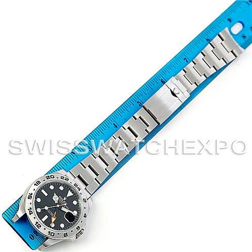 This image shows a Rolex Explorer 216570 Men's Stainless Steel Black Dial 216570 Men's Stainless Steel Black Dial watch laid flat alongside a blue ruler, highlighting its bracelet and clasp.