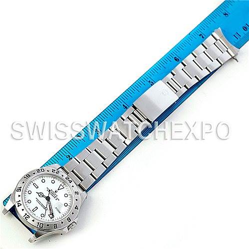 This image shows a top view of a Rolex Explorer 16570 Men's Stainless Steel White Dial 16570 Men's Stainless Steel White Dial watch with a stainless steel bracelet next to a blue ruler for scale.