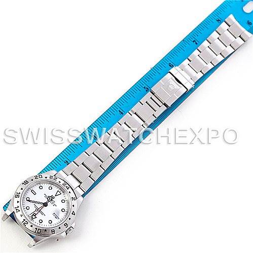 The image shows an overhead view of a Rolex Explorer 16570 Men's Stainless Steel White Dial 16570 Men's Stainless Steel White Dial watch and bracelet against a blue ruler.