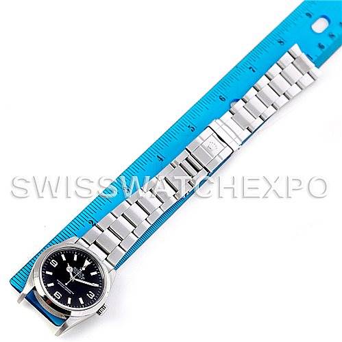 The image shows a Rolex Explorer 114270 Men's Stainless Steel Black Dial 114270 Men's Stainless Steel Black Dial watch with its full stainless steel bracelet, positioned next to a blue ruler for scale.