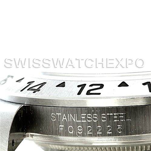 The image shows a close-up of the Rolex Explorer 16570 Men's Stainless Steel White Dial 16570 Men's Stainless Steel White Dial's stainless steel case and engraved bezel, highlighting the serial number.