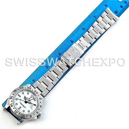 This image shows the Rolex Explorer 16570 Men's Stainless Steel White Dial 16570 Men's Stainless Steel White Dial model watch from a top-down angle, alongside a blue ruler for scale.