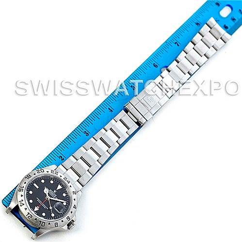 The image shows the Rolex Explorer 16570 Men's Stainless Steel Black Dial 16570 Men's Stainless Steel Black Dial watch laid flat with a metal bracelet next to a blue ruler for scale.