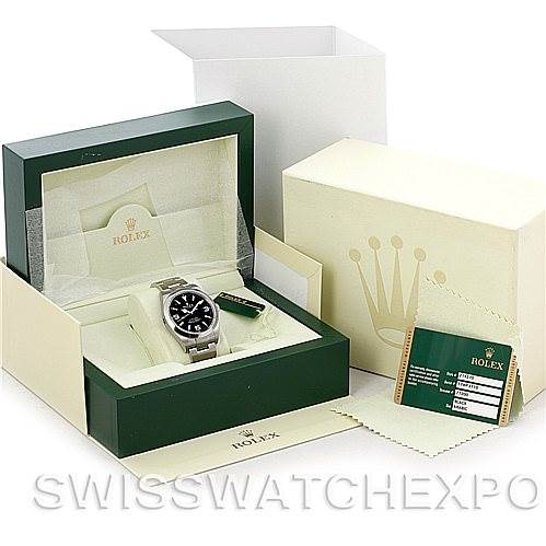 The image displays a Rolex Explorer 214270 Men
s Stainless Steel Black Dial 214270 Men
s Stainless Steel Black Dial watch inside its original green box, with the outer box, tags, and warranty card visible.