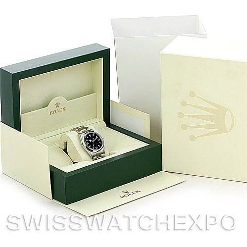 The image shows a Rolex Explorer 114270 Men's Stainless Steel Black Dial 114270 Men's Stainless Steel Black Dial model watch in its green and cream-colored box, with additional packaging visible behind.