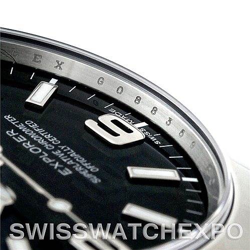 This image shows a close-up angle of the Rolex Explorer 214270 Men's Stainless Steel Black Dial 214270 Men's Stainless Steel Black Dial watch's dial, highlighting part of the chapter ring, markers, and numerals.