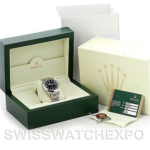The image shows a Rolex Explorer 214270 Men's Stainless Steel Black Dial 214270 Men's Stainless Steel Black Dial watch, its green display box, white outer box, warranty card, and tags viewed from an angled top perspective.