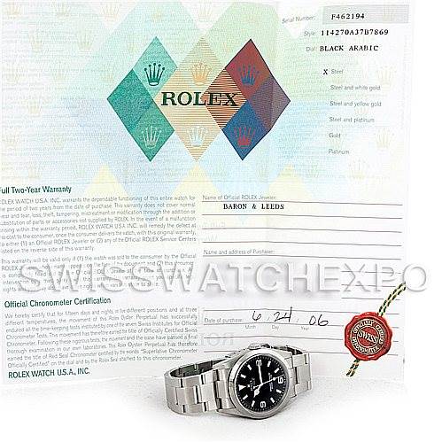 The image shows the Rolex Explorer 114270 Men's Stainless Steel Black Dial 114270 Men's Stainless Steel Black Dial watch at an angle from the top left, along with its certification papers and warranty card.