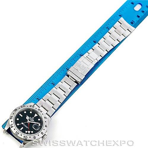 The image shows a Rolex Explorer 16570 Men's Stainless Steel Black Dial 16570 Men's Stainless Steel Black Dial watch laid flat, with the dial and bracelet visible next to a blue ruler.